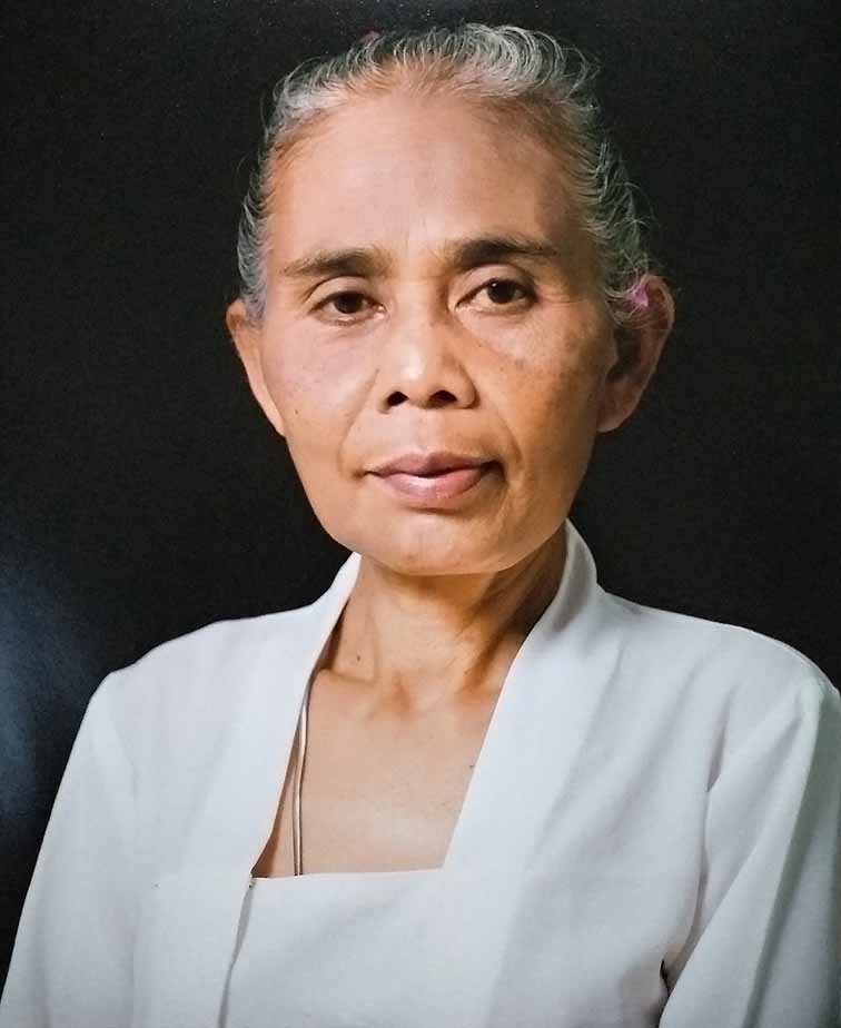 <p><strong>Mangku Muriati</strong> (b. Kamasan, Bali, Indonesia) is a Balinese painter and priestess from Kamasan village near Klungkung. Muriati paints in traditional Balinese form, known as Kamasan-style, where aesthetic form and narration relate to the Wayang Kulit puppet theatre. This form of painting is associated with the East Javanese kingdom of Majapahit, which flourished in the 14th and 15th centuries and helped to propagate Hindu faith across the region – now largely retained in Bali. It was from the Kamasan village where artists were traditionally recruited to produce classical-style paintings on cloth (or bark) for religious and ceremonial use as well as to decorate the palaces and temples. Mangku Muriati is the daughter of Mangku Mura (1920-1999), who is considered one of the prominent artists of his generation in Kamasan-style painting. As is common practice in artist families, Muriati used to help her father in colouring paintings from an early age, learning the craft of painting. She studied art at the Udayana University in Denpasar, Bali, and after graduating, returned to the traditional style of painting. In the 1990s, at the age of 32, Muriati became a priestess at her local temple in the ward of Banjar Siku. She considers painting and priestly duties as complementary, comparing the role of an artist to a dalang or puppet master, who needs extensive knowledge of characters and stories, ultimately derived from what is considered the sacred scripture: the Hindu epics Ramayana and Mahabharata. The subjects of her paintings and related commentaries frequently refer to social and political issues in contemporary Bali, such as recently the Covid-19 pandemic or portraits of colleagues and herself. In 2023 in collaboration with HFA and Biasa Art, V-Room presented Mangku Muriati’s solo exhibition <em>Year of the Tiger </em>in Ubud, Bali. Muriati's paintings have been exhibited and collected in Bali as well as internationally.</p>